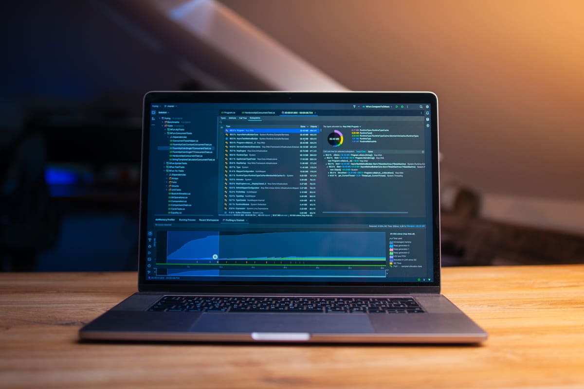 Laptop on a wooden desk showing custom code for a client website